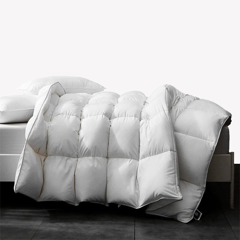 APSMILE white down comforter on a bed with two pillows.