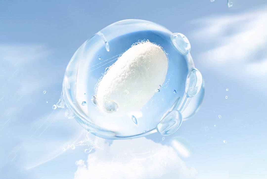 Silk material repels water inside a clear droplet with blue sky background.
