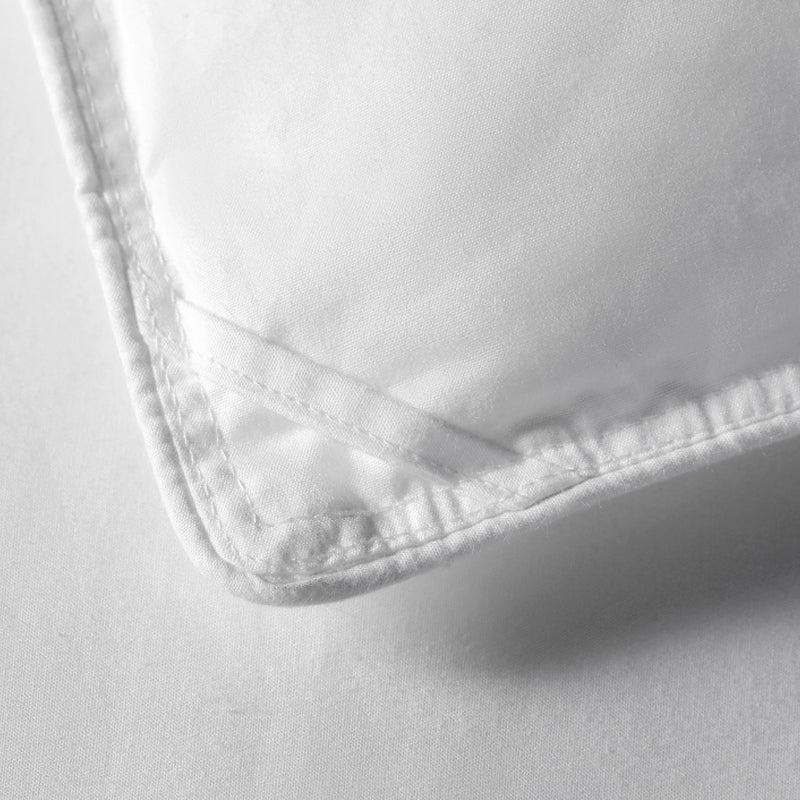 Close-up of APSMILE white down comforter with piped edges.