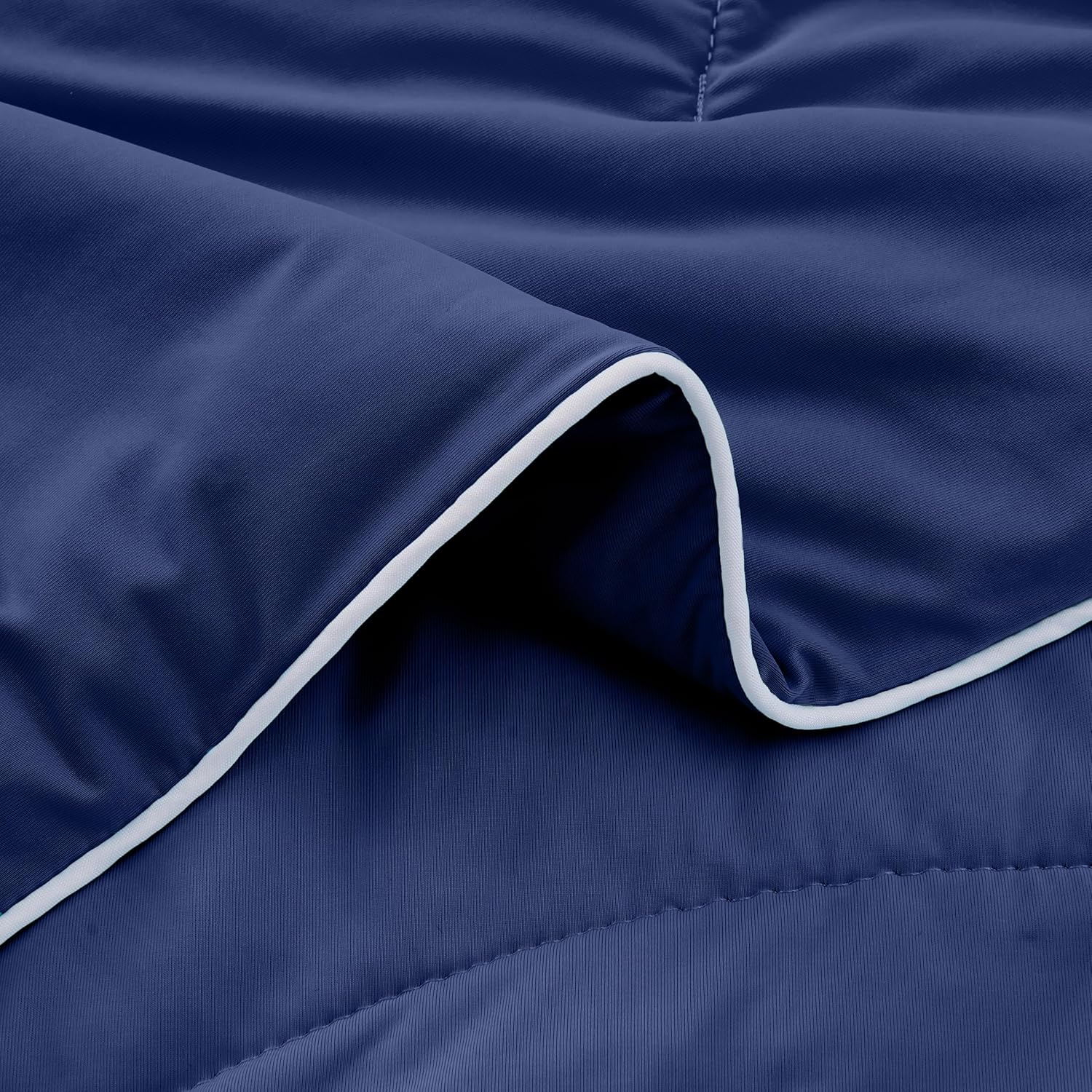 Close-up view of the APSMILE cooling blanket in a deep navy blue with white trim.