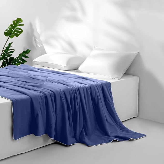 APSMILE cooling blanket in royal blue on a white bed with pillows set against a white wall.