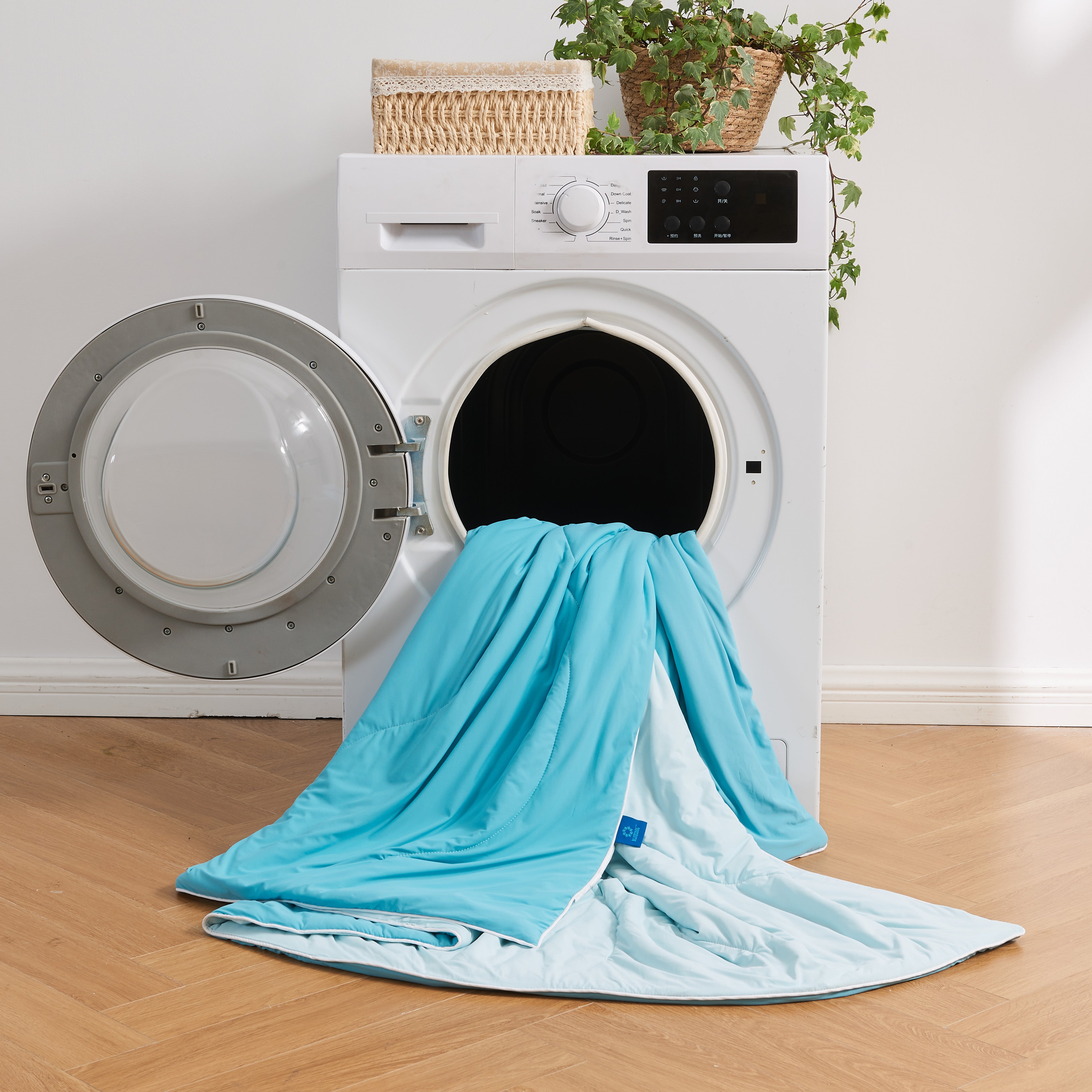 APSMILE cooling blanket, predominantly light blue, emerging from the open door of a white front-loading washing machine.