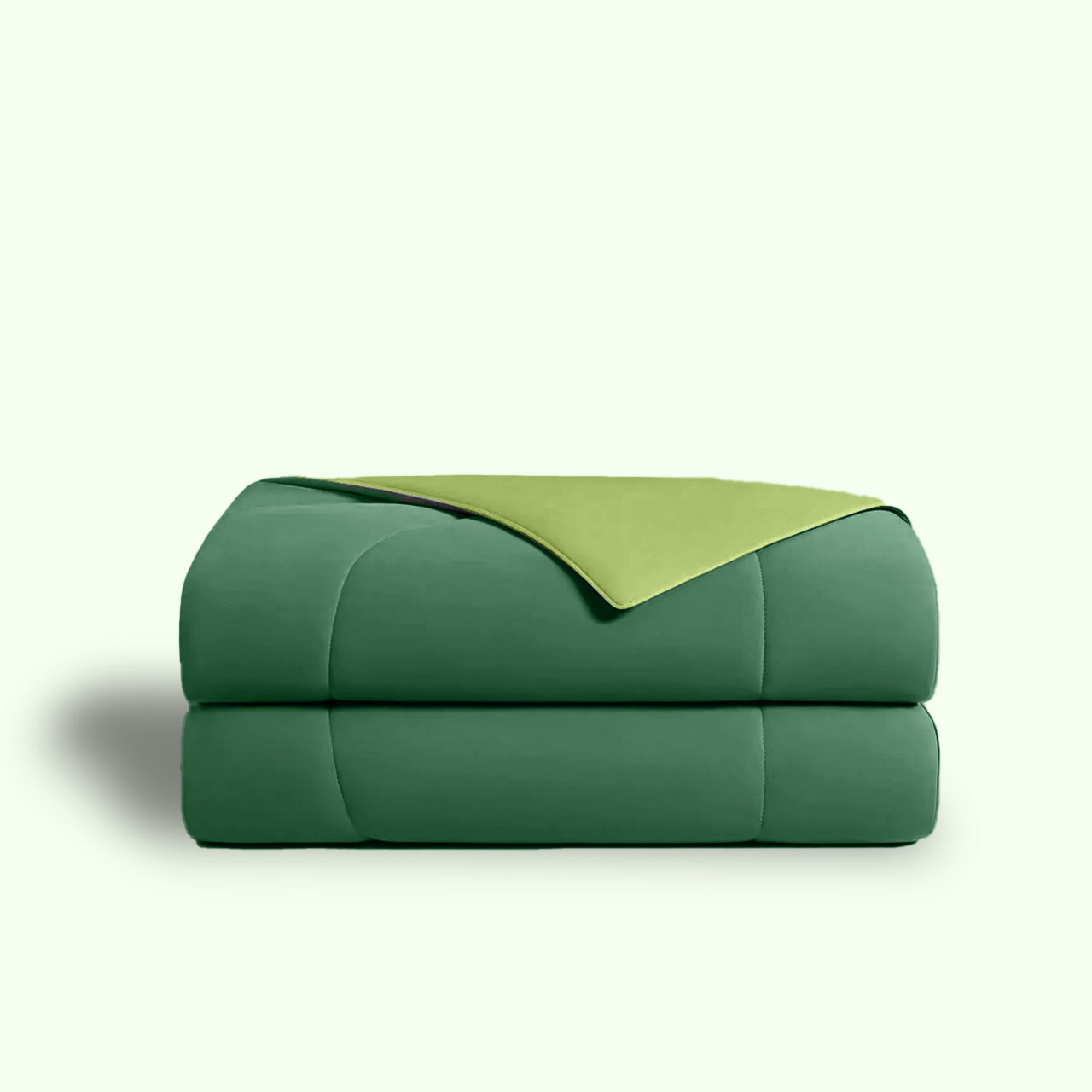 Stacked green and light green comforter on a white background.