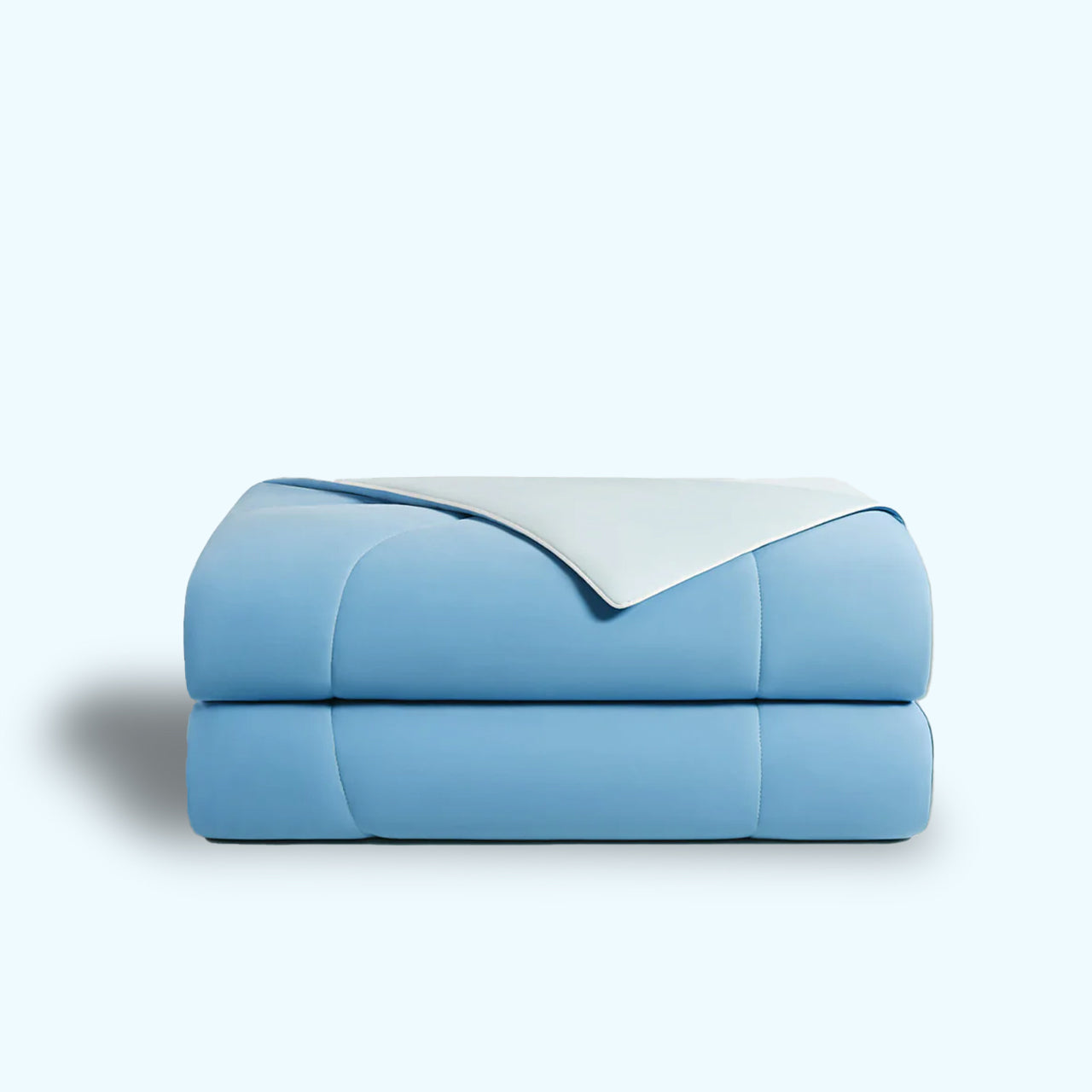 Light blue comforter with white accent, folded against a pale blue background.