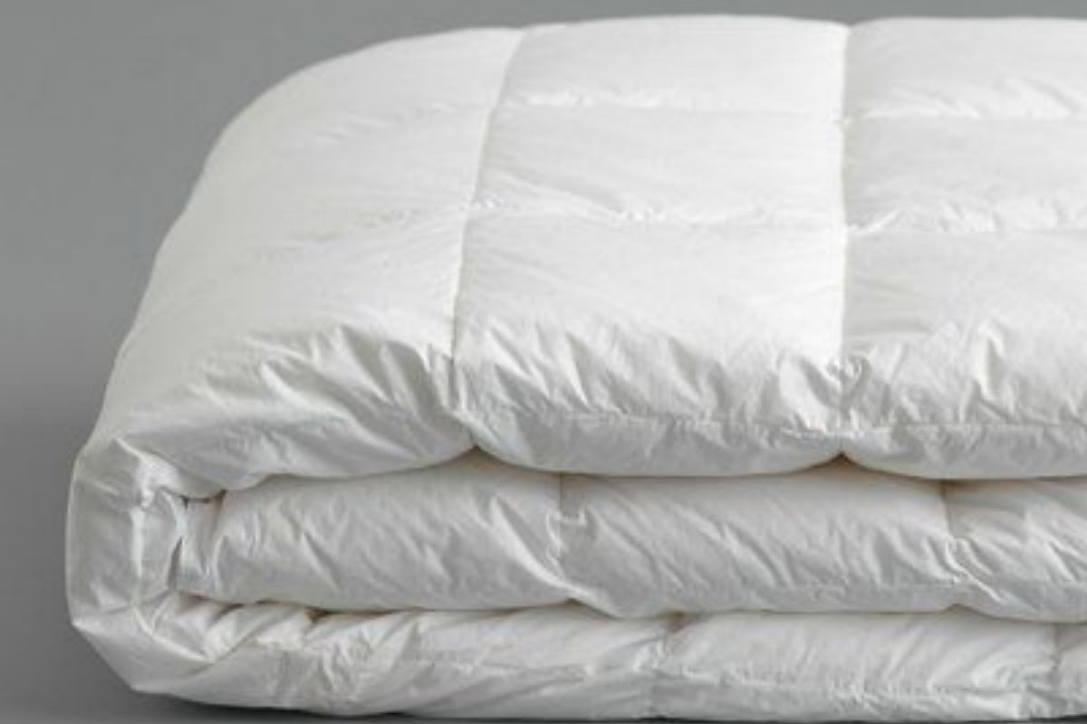A neatly folded white duvet, relevant to inserting a duvet.
