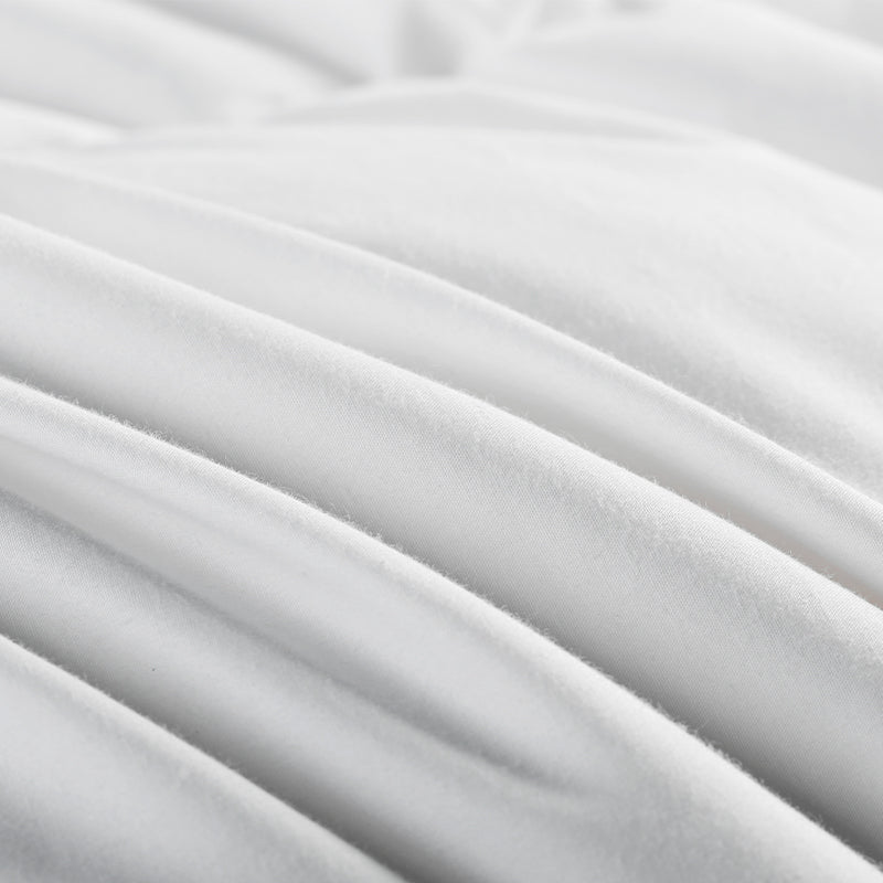 Close-up of the textured, pure white APSMILE down comforter, showcasing its soft, rippled fabric.
