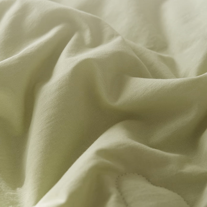 Close-up of draped, light beige fabric with soft ridges and subtle stitching detail.
