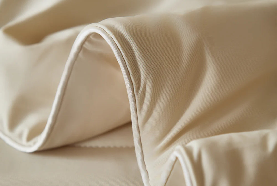 Close-up of tan fabric with a raised edge and white piping.