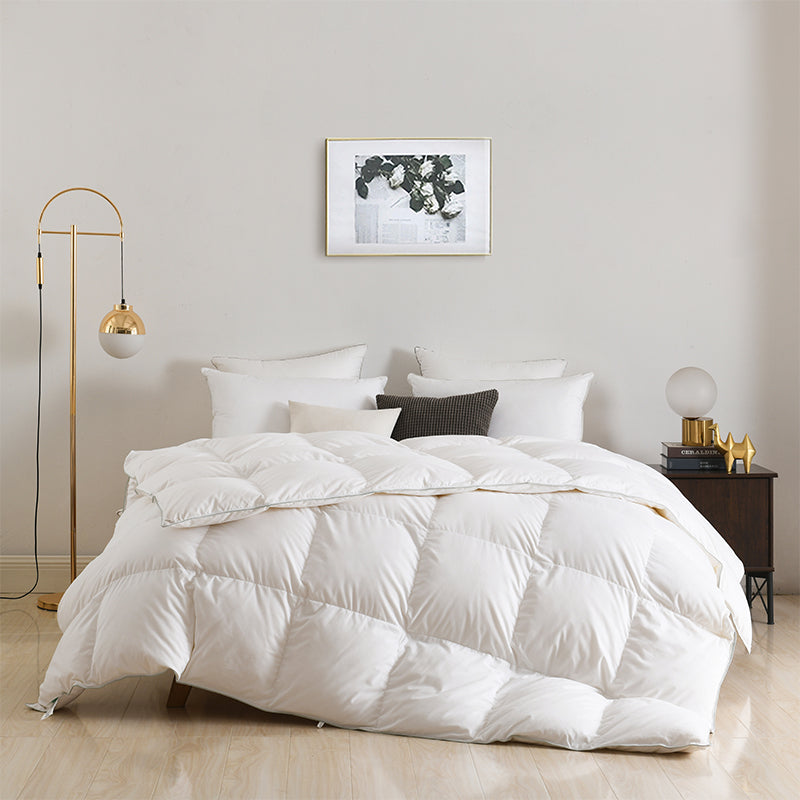 APSMILE white down comforter on a bed with a framed floral print hanging above the headboard.